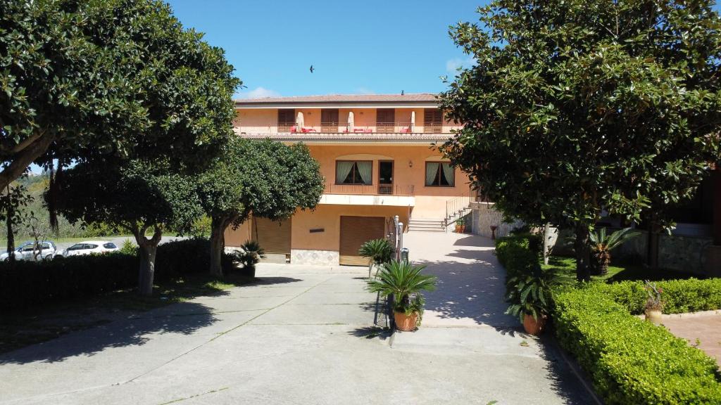 een huis met een oprit en bomen ervoor bij La nuova locanda in Orsomarso