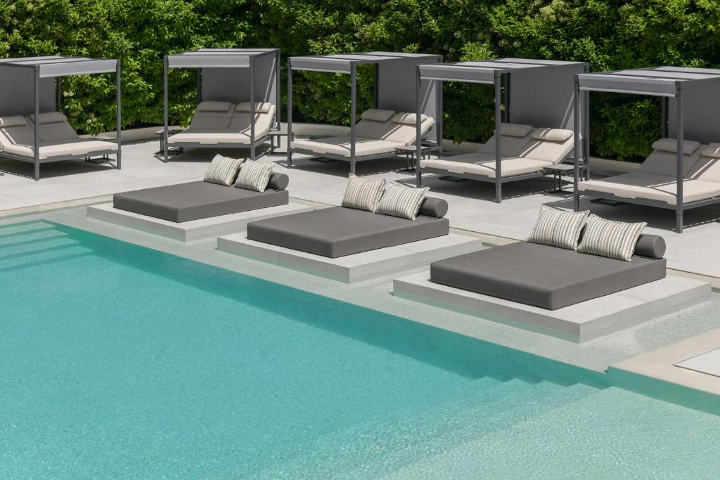 a group of lounge chairs next to a swimming pool at Blazer Suites Hotel in Athens