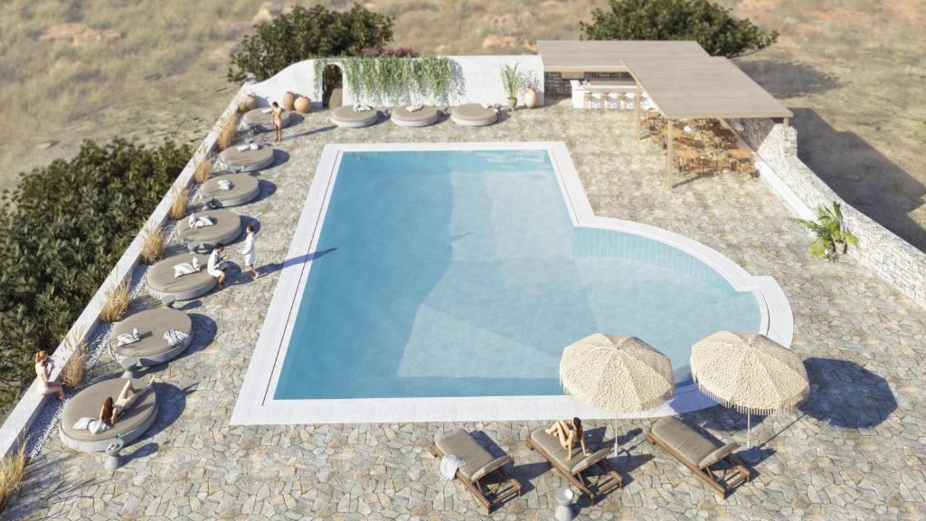 uma vista superior para uma piscina com cadeiras e guarda-sóis em Philosophy of Mykonos em Glastros