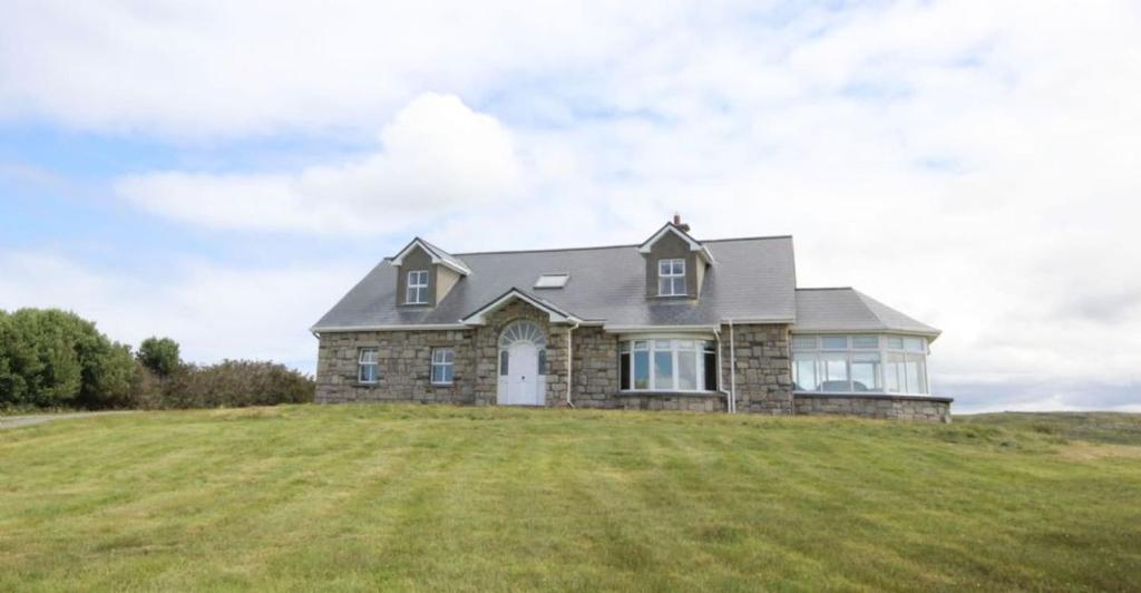 a house on top of a grassy hill at Jackie's Cottage in Claddaghduff