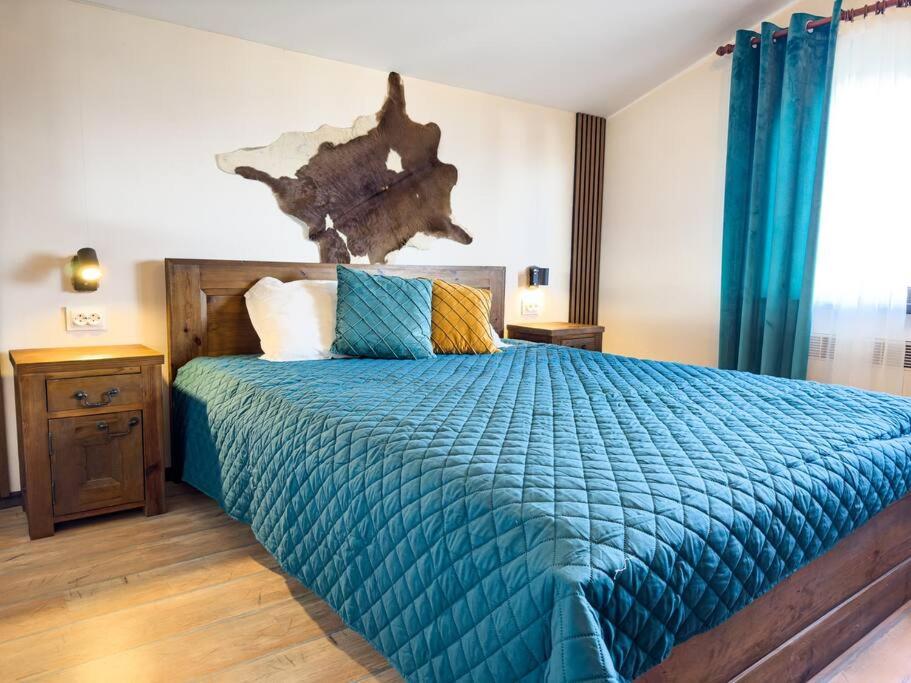 バンスコにあるPrivate cozy at Alpin Lodge Studio + SPA Complexの青い掛け布団が敷かれたベッドのある寝室