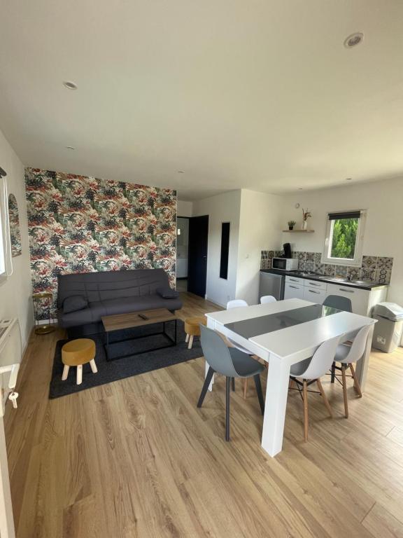 ein Wohnzimmer mit einem Tisch und einem Sofa in der Unterkunft Les Chalets du Mancel : Chalet Lulu - Bouleries Jump - 24h du Mans in Parence