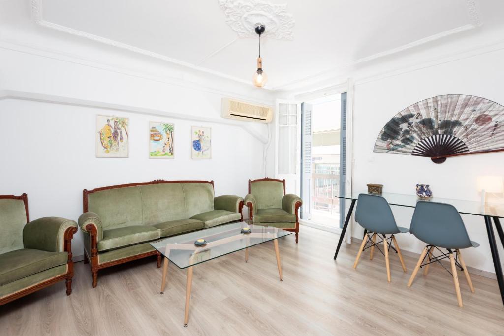 ein Wohnzimmer mit Sofas, einem Tisch und Stühlen in der Unterkunft Beautiful Neo-Classic apartment in Exarchia (1Bed) in Athen