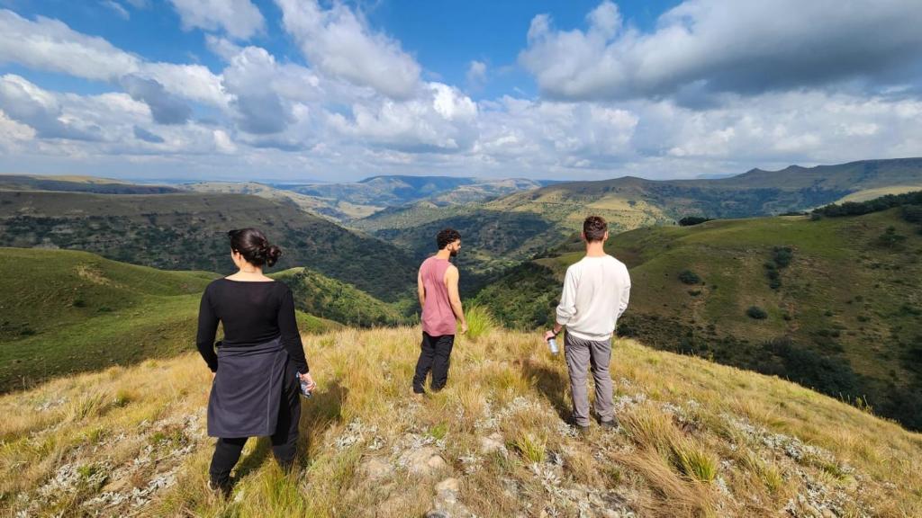 a group of three people standing on top of a hill at Highlands Farm Cottage in Van Reenen