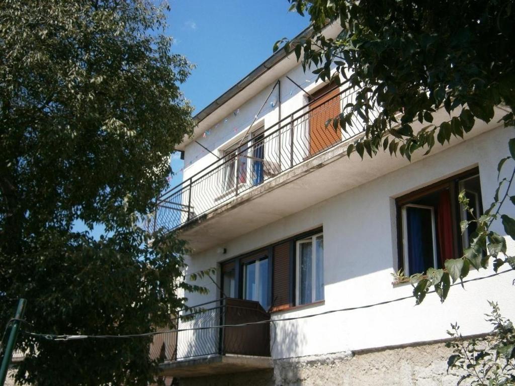 Ein Mann steht auf einem Balkon eines Gebäudes in der Unterkunft Appartement in Novi Vinodolski mit Terrasse, Garten und Grill in Novi Vinodolski