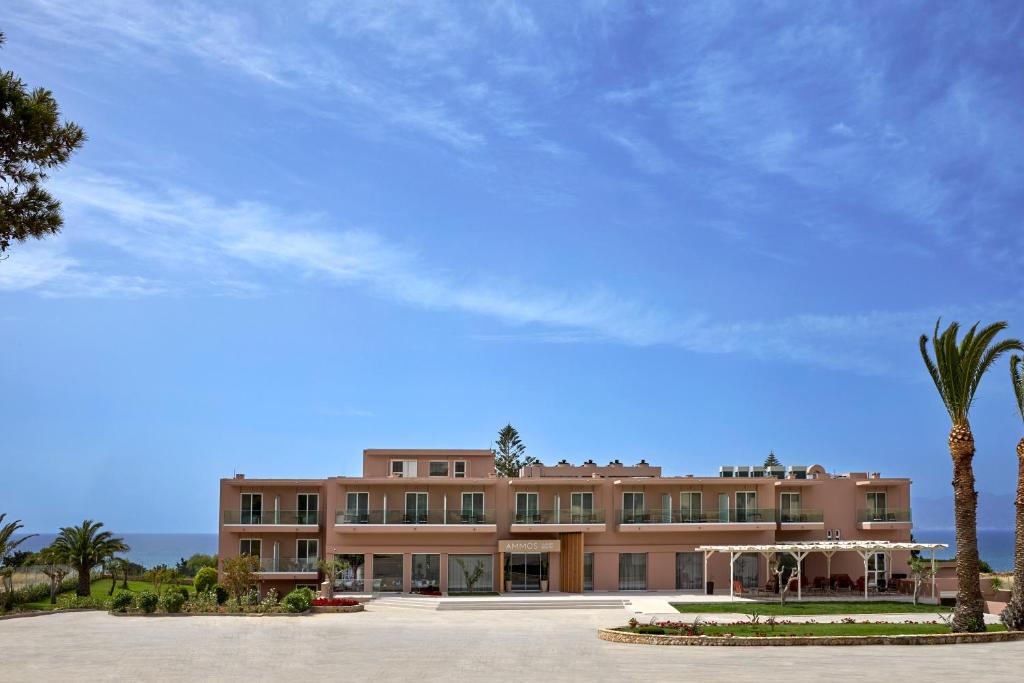 ein großes Gebäude mit einer Palme davor in der Unterkunft Ammos Luxury Resort in Mastichari
