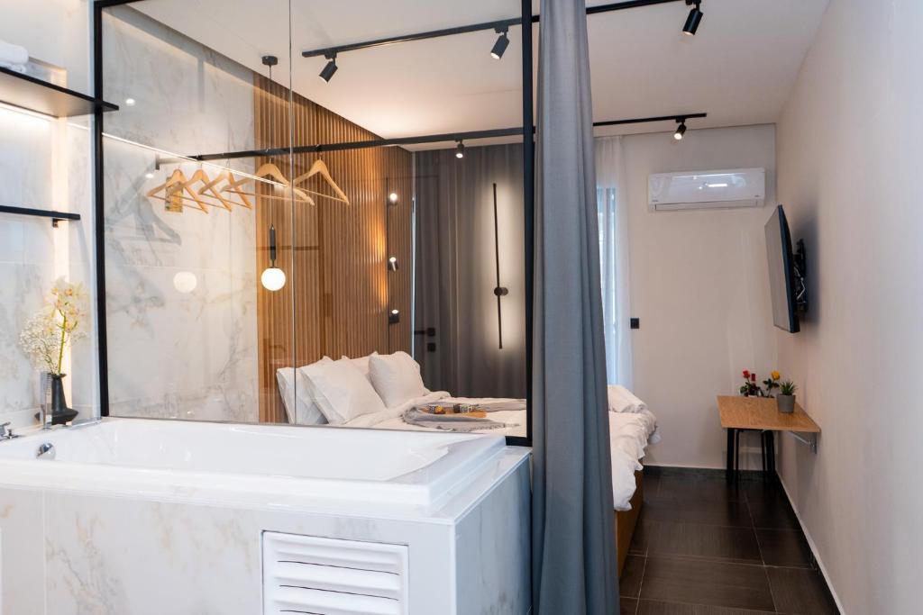 a bathroom with a tub and a large mirror at Mini luxury suites by Sea&theCity in Thessaloniki