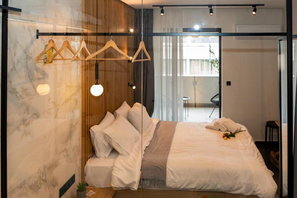 テッサロニキにあるLuxury suites with JACUZZI by Sea&theCityのベッド1台が備わるガラスの壁の客室です。