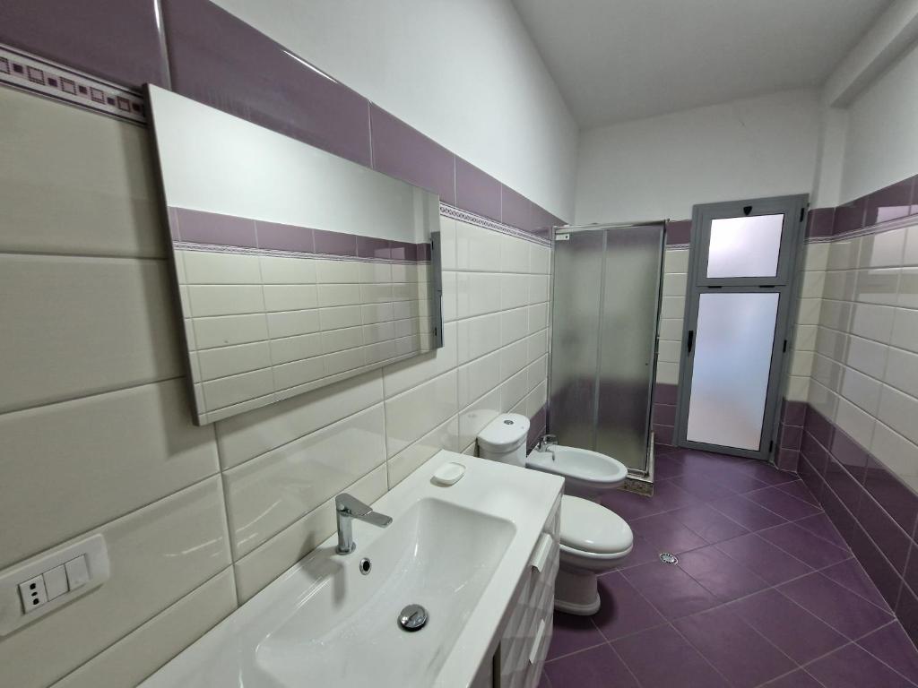 Appartamento Perla في فلوره: حمام مع حوض ومرحاض ومرآة