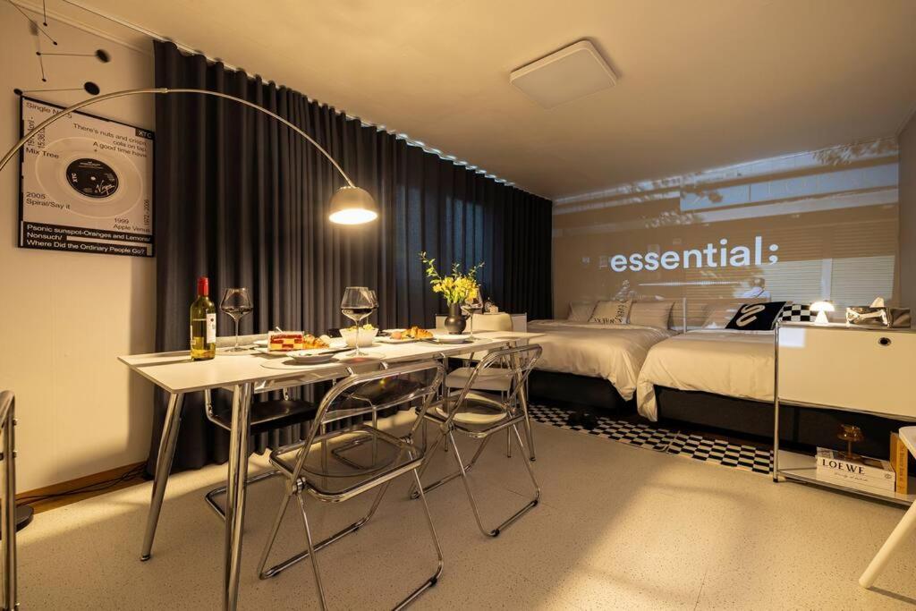 a room with a bed and a table and chairs at Luxury Gallery Stay in Seoul