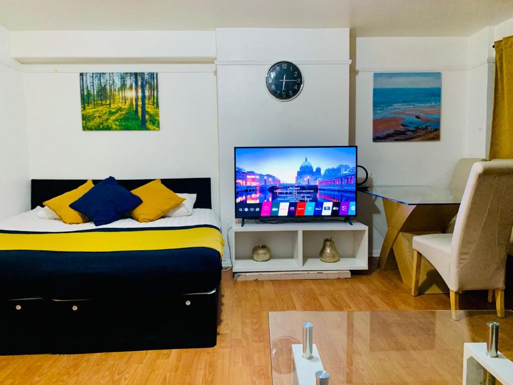a bedroom with a bed with a television and a desk at London Stratford 4 Bedrooms Apartment in London
