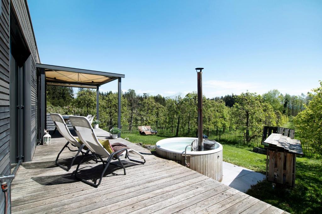 eine Terrasse mit 2 Stühlen und einer Badewanne in der Unterkunft Bodensee Oberschwaben in Horgenzell