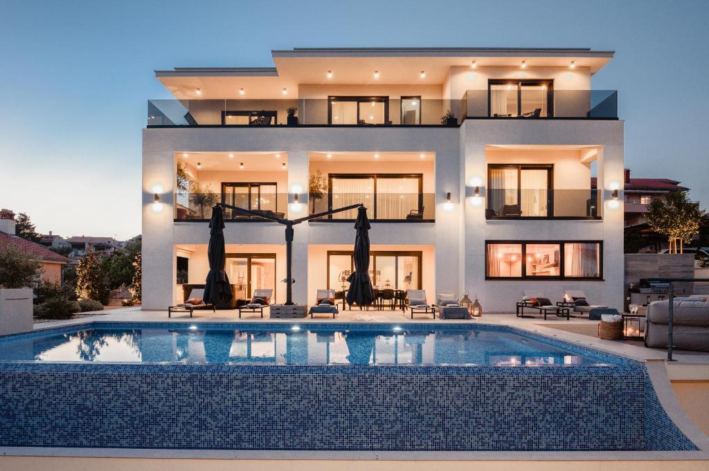 a house with a swimming pool in front of it at Luxury Villa Mikolina in Kornić