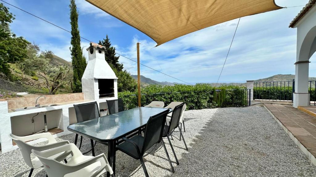 patio ze stołem i krzesłami oraz piecem do pizzy w obiekcie Villa Málaga con Piscina Vallada, Barbacoa y hermosas vistas by AndaraHolidays w Maladze