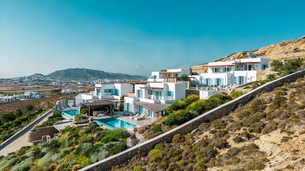 a row of white houses on a hill at Chrysanthemo villas in Ano Mera