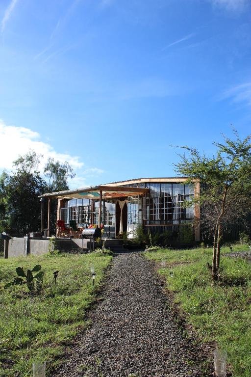 a house with a gravel road in front of it at The Cascades Cabin Nakuru in Nakuru