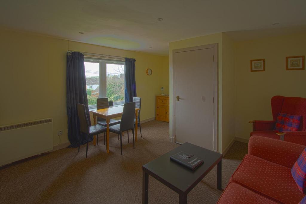 a living room with a table and a dining room at Harbour Inn Appartments in Garlieston