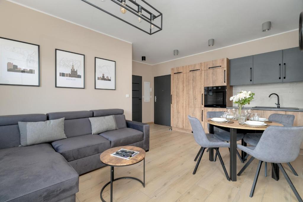 ein Wohnzimmer mit einem Sofa und einem Tisch in der Unterkunft Cosy and Bright Apartment with Parking in Poznan by Renters in Posen