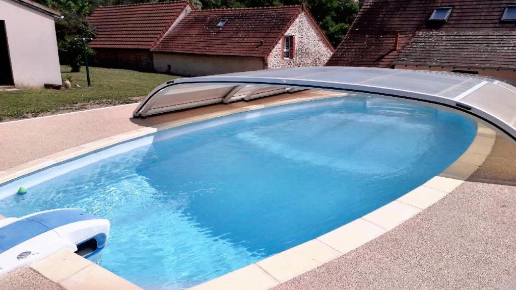 - une piscine avec un toit en métal dans l'établissement Maison d'une chambre avec piscine partagee terrasse amenagee et wifi a Saint Victor, à Saint-Victor