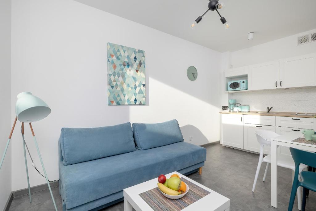 a living room with a blue couch and a table at Seaside Apartment with Balcony in Pobierowo - Close to Beach by Renters in Pobierowo