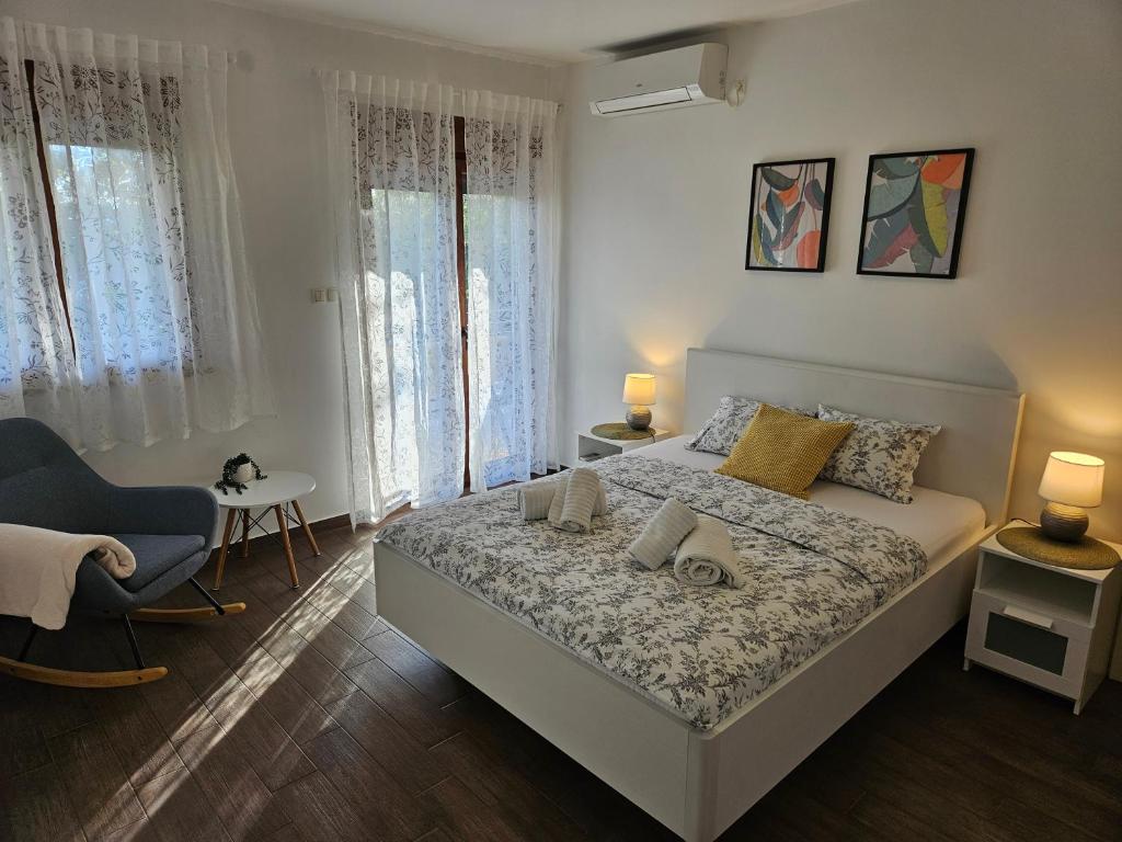 a bedroom with a bed and a chair and windows at Kristy's Place in Crikvenica