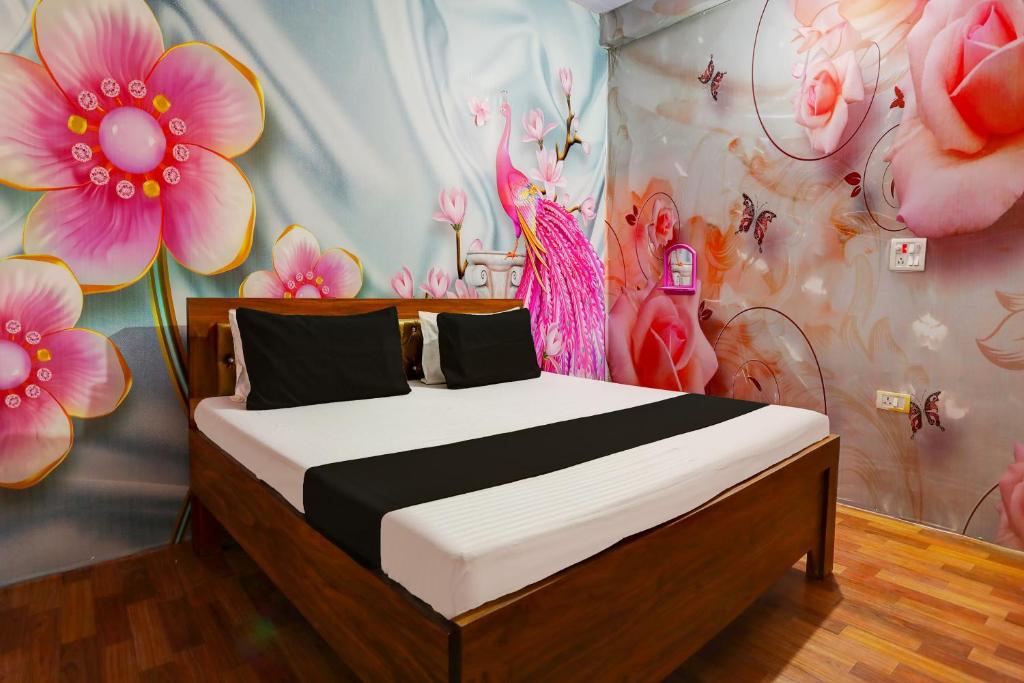 sypialnia z łóżkiem z kwiatami na ścianie w obiekcie OYO WELCOME GUEST HOUSE w mieście Rudrapur