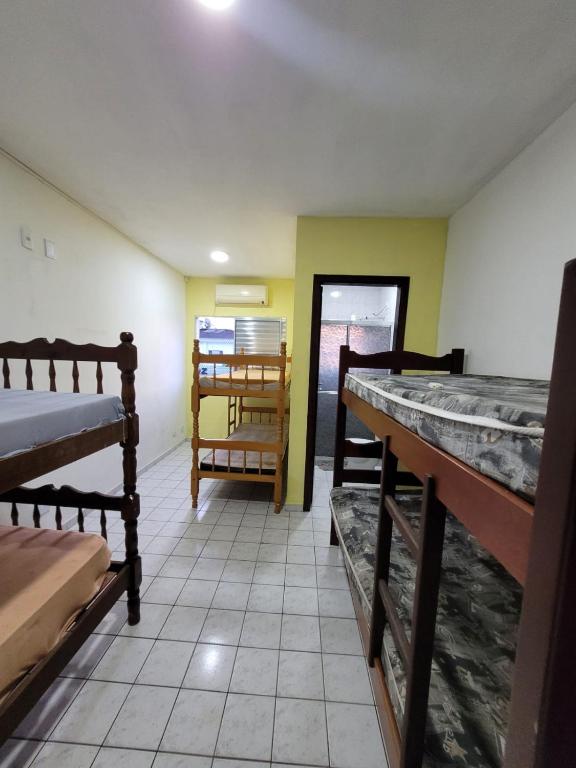 Habitación con 2 literas y mesa. en Cantinho do Mar Pousada en Bertioga
