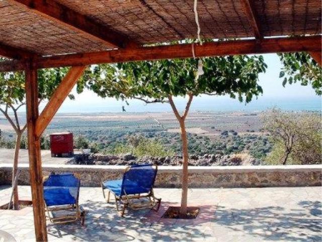 two blue chairs sitting on a patio with a view at Patsianos Traditional House in Frangokastello