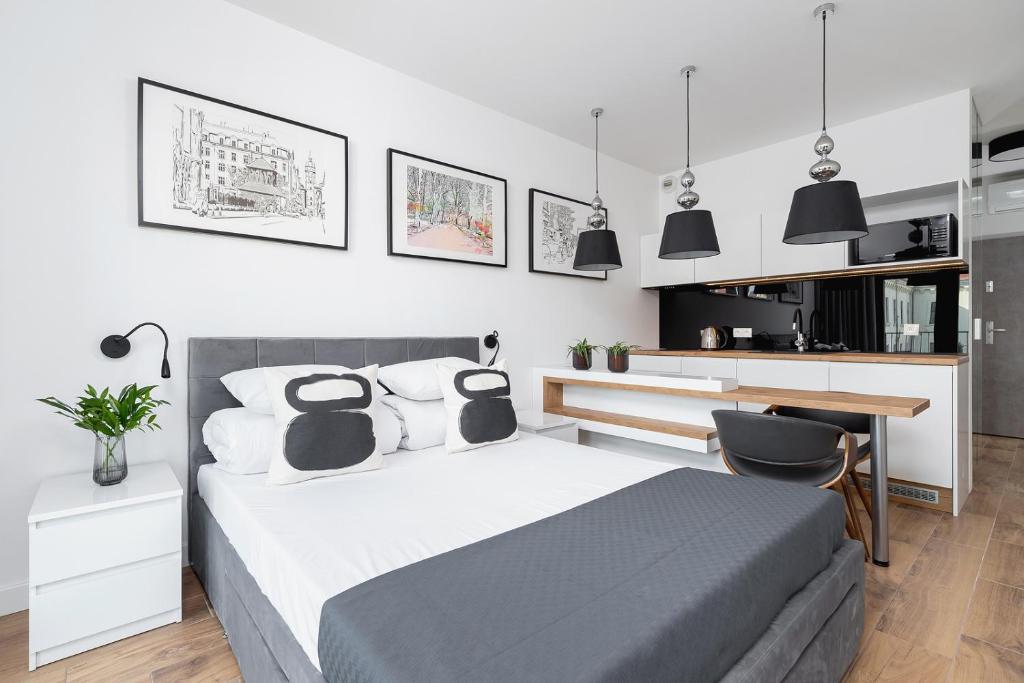 a bedroom with a bed and a desk and some lights at Studio with a balcony and AC - Rajska 3 street in Kraków