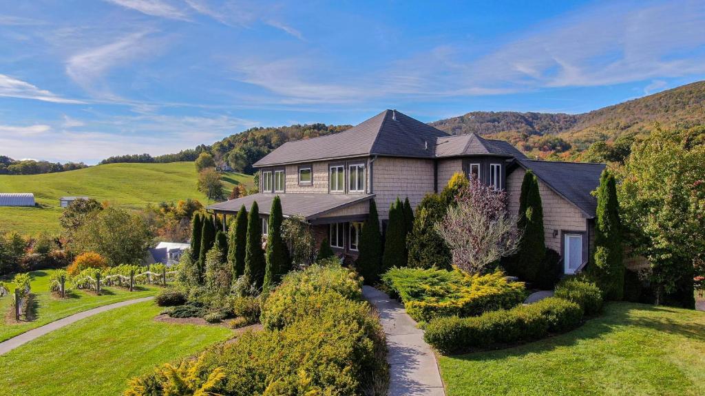 a large house with a garden in front of it at Banner Elk Winery Villa in Banner Elk