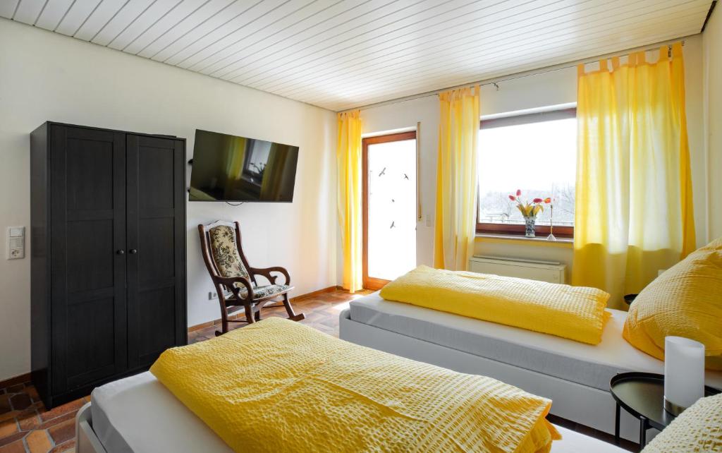 um quarto com 2 camas, uma cadeira e uma janela em Wäller Abendsonne em Westerburg