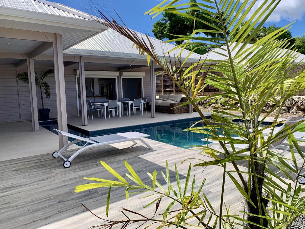 a villa with a swimming pool and a house at Nakolodge -3 chambres - piscine et jardin privatifs in Sainte-Anne