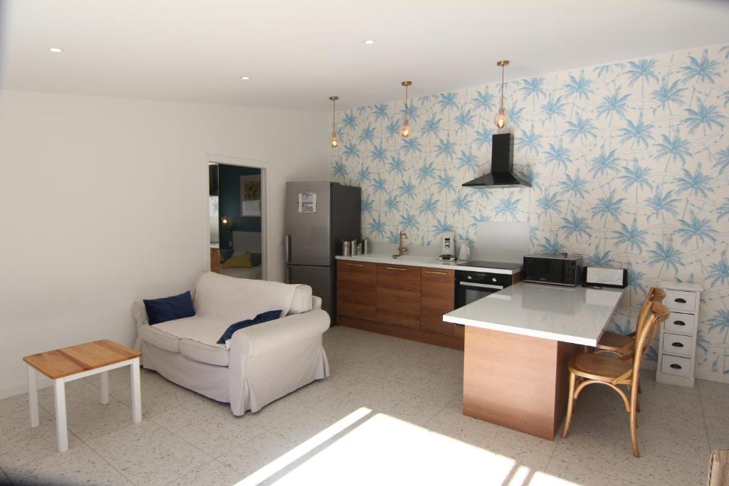 Una cocina con un sofá, una silla y una mesa. en Clos Emilie, en La Seyne-sur-Mer