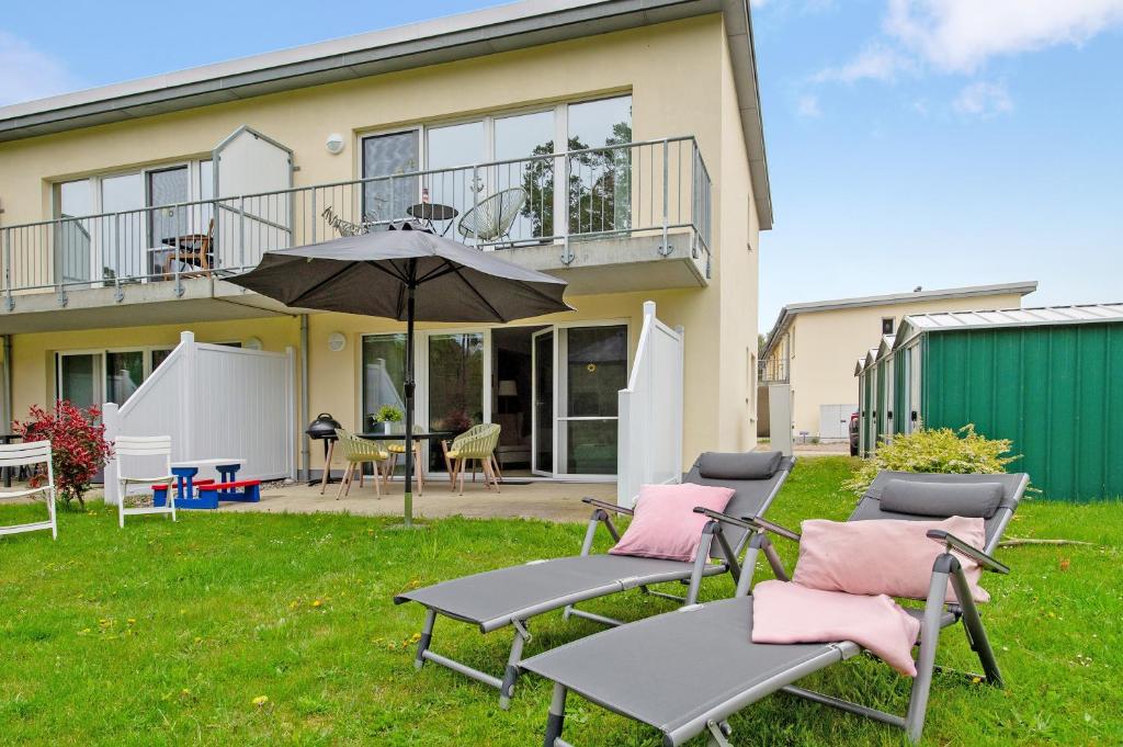 een patio met stoelen en een parasol voor een huis bij Lieblingsinsel in Graal-Müritz