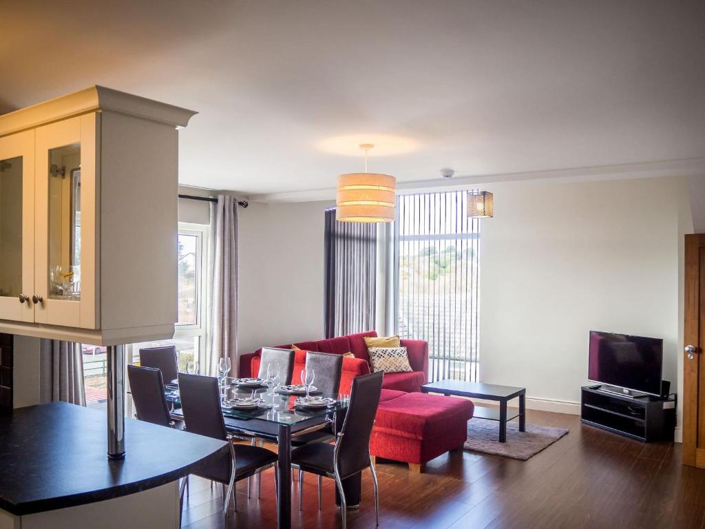 a living room with a red couch and a table at Carraroe Apartment in Carraroe