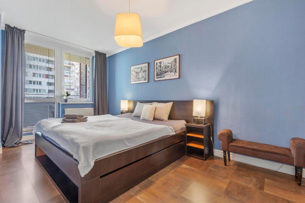a bedroom with a bed and a blue wall at Tomato Apartment - With free parking in Bratislava