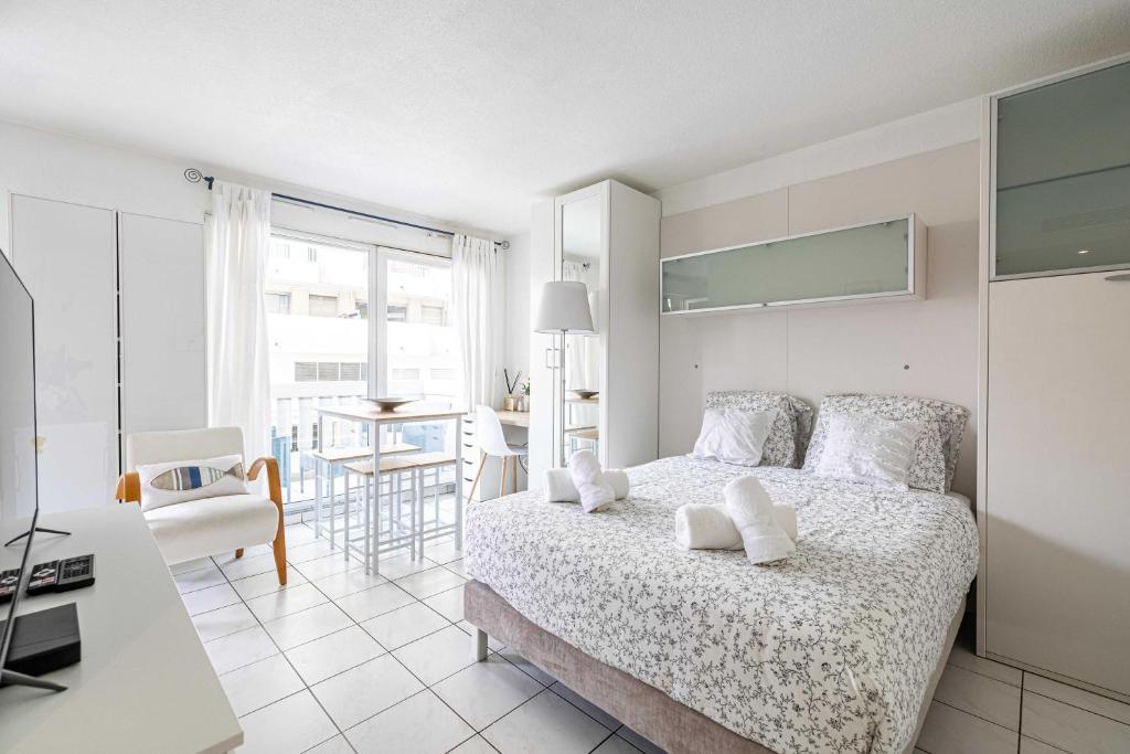 Dormitorio blanco con cama y mesa en Charming Studio with balcony & Clim -Heart of Nice, en Niza