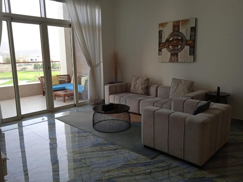 ein Wohnzimmer mit 2 Sofas und einem großen Fenster in der Unterkunft Sifah Inn in As Sīfah