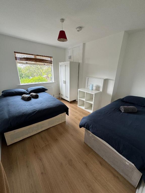 sypialnia z 2 łóżkami i oknem w obiekcie Nice Triple Room at 2 Iveragh Rd-6 w Dublinie