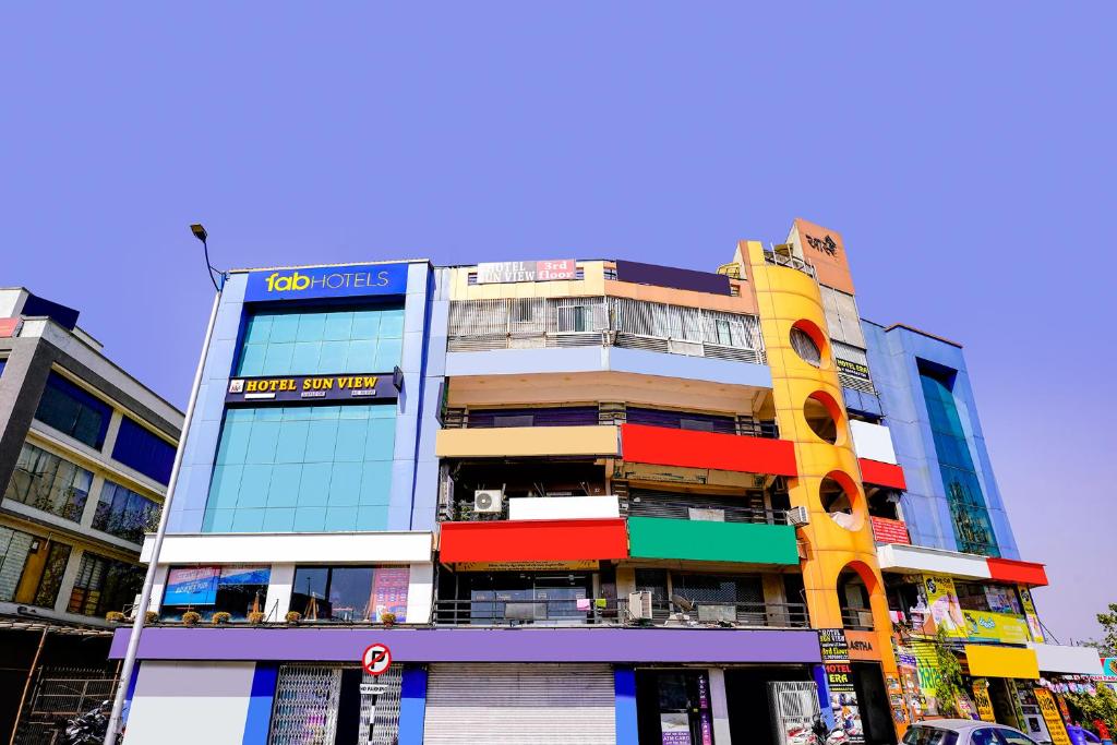 un edificio alto con finestre colorate su una strada di città di FabHotel Sun View a Ahmedabad