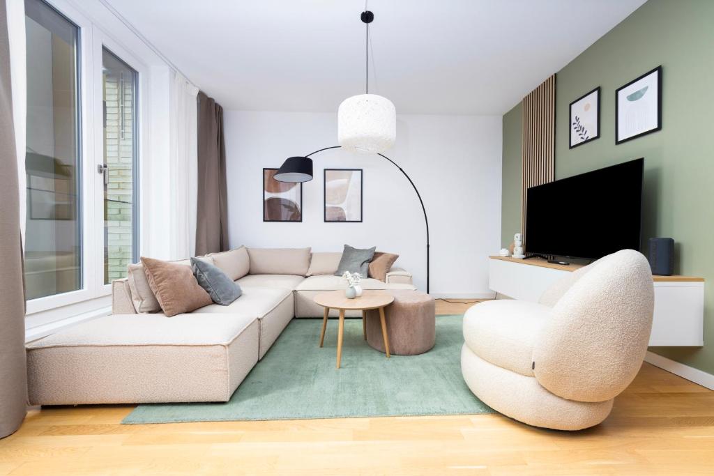 ein Wohnzimmer mit einem weißen Sofa und einem TV in der Unterkunft SpaciousLiving Oldtown - citycenter - free parking in Dresden
