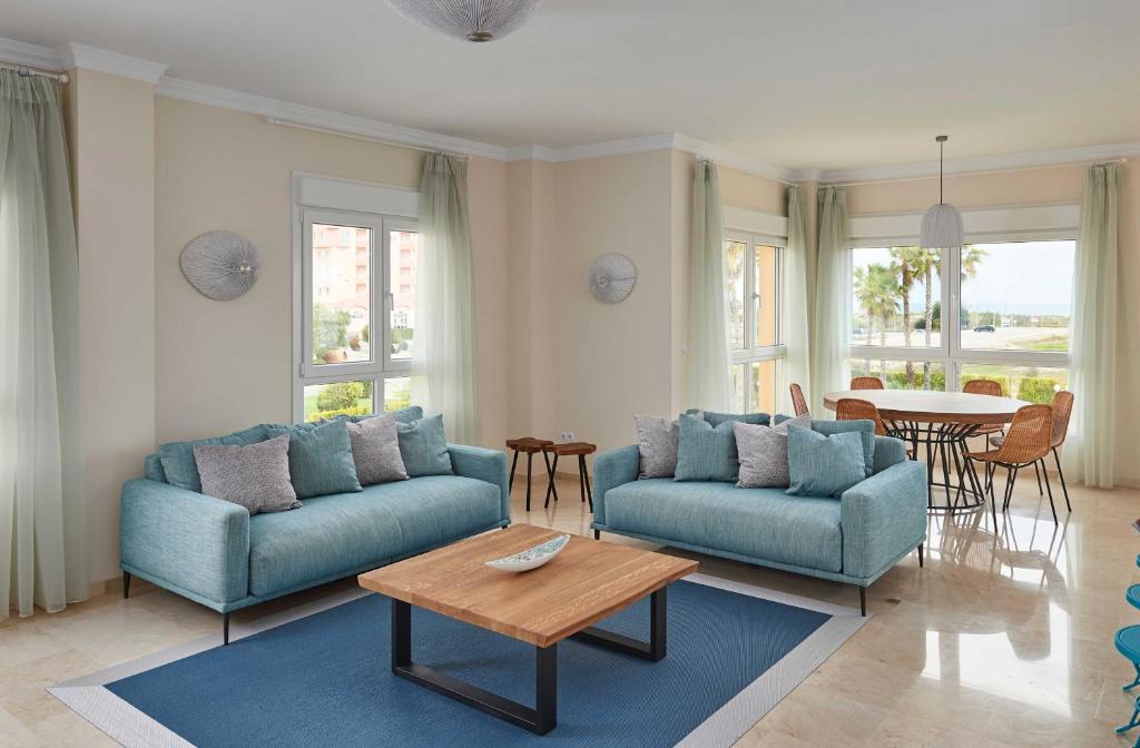 uma sala de estar com dois sofás azuis e uma mesa em Bogey by Oliva Nova em Oliva