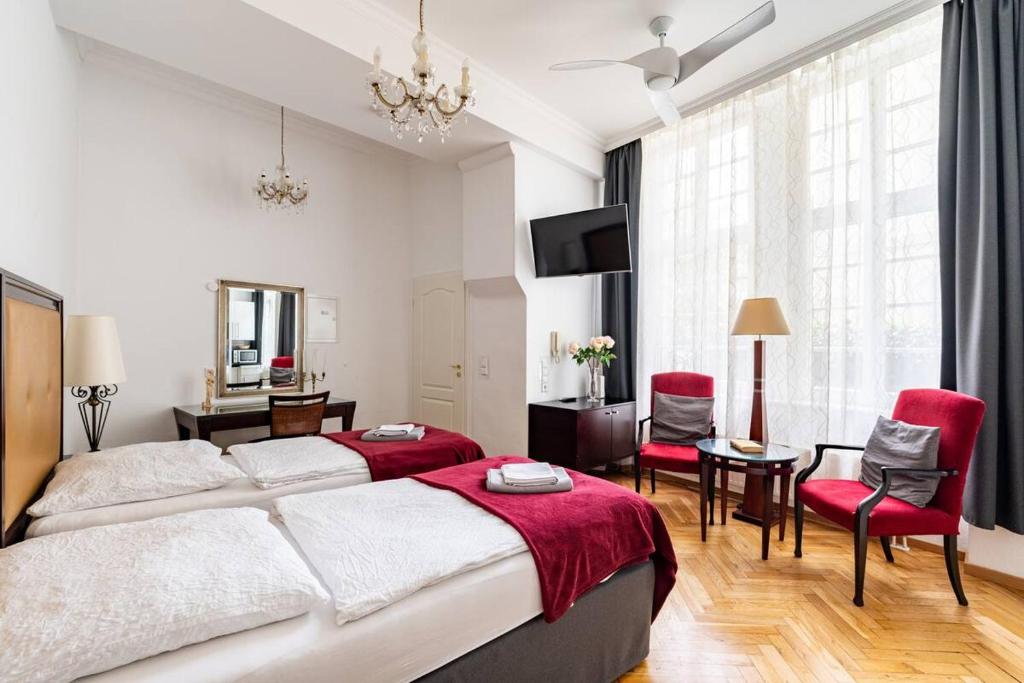 1 dormitorio con 1 cama grande y sillas rojas en Studio an der Therme en Baden-Baden