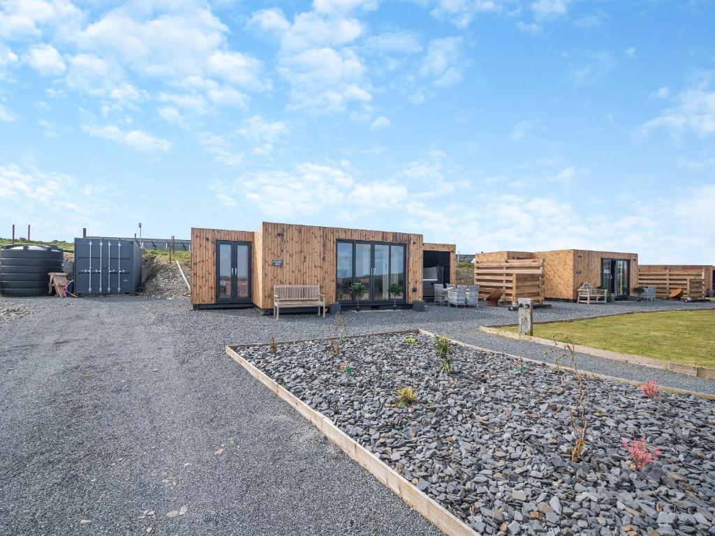 a house with glass doors on a gravel yard at Galloway Views - Uk46816 in Wigtown