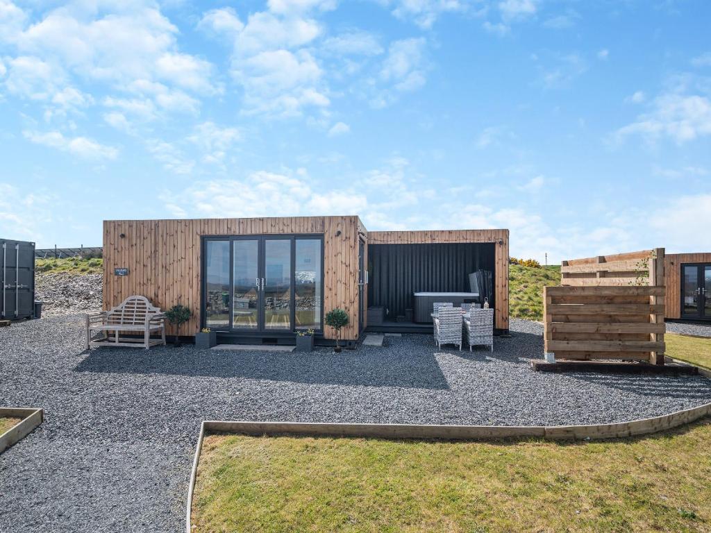 a small wooden building with a bench in a yard at Galloway Hills - Uk46817 in Wigtown