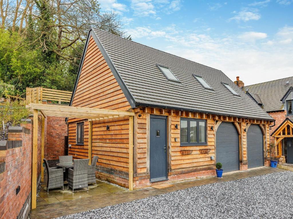 Cabaña de madera con porche y puerta azul en Fallows Holt, en Buildwas