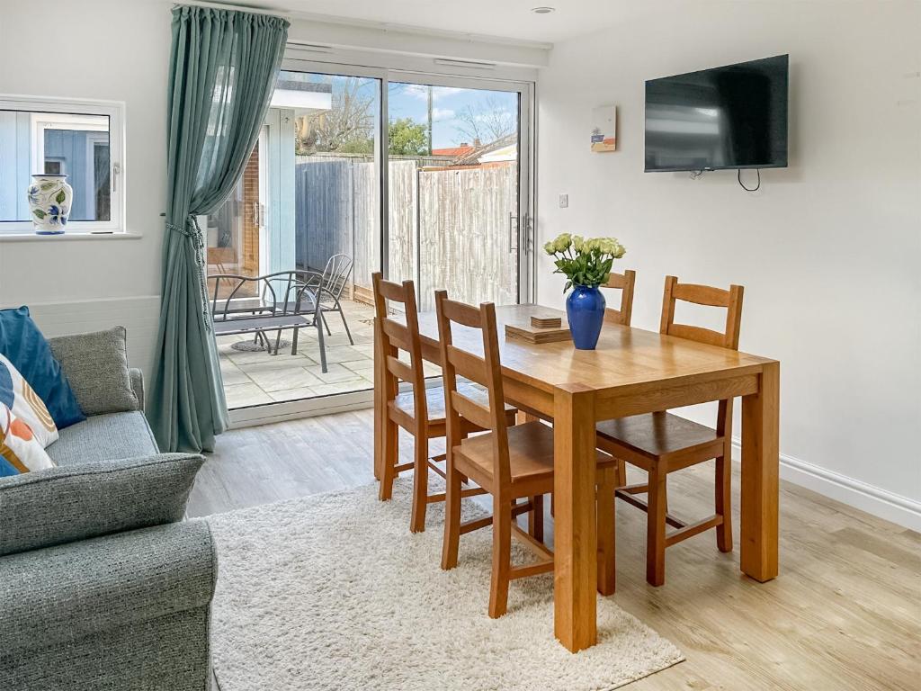 a living room with a table and chairs and a couch at Rectory Cottage - Uk46995 in Overstrand