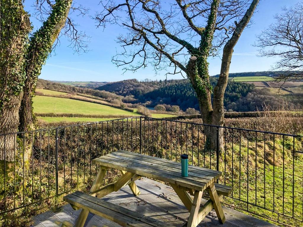 a wooden picnic table with a cup on top of it at The Platt in Dunterton