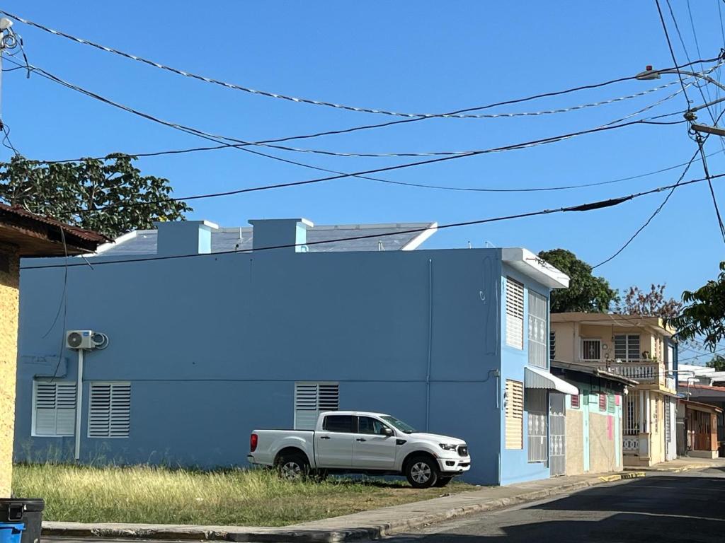 un camión blanco estacionado al lado de un edificio azul en Santoni’s Luxury Rentals, en Cabo Rojo