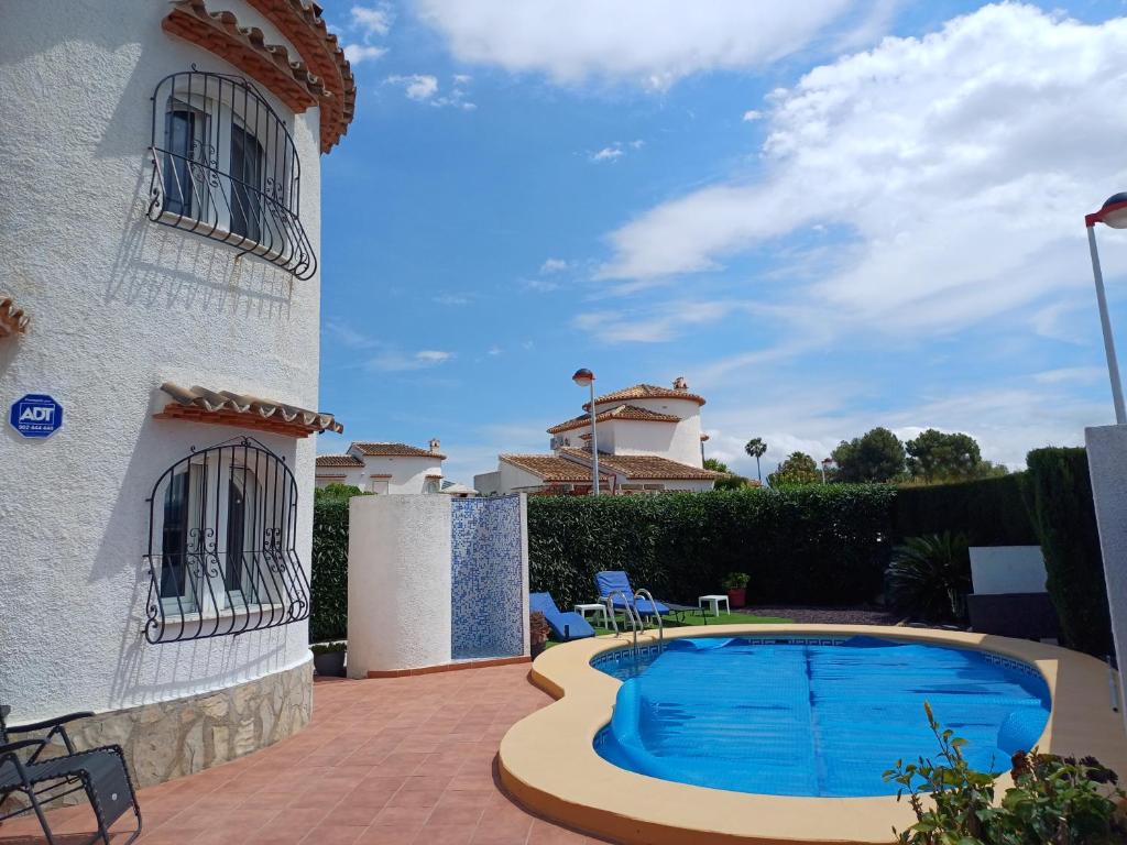 a villa with a swimming pool in front of a building at Coquet studio indépendant in Els Poblets